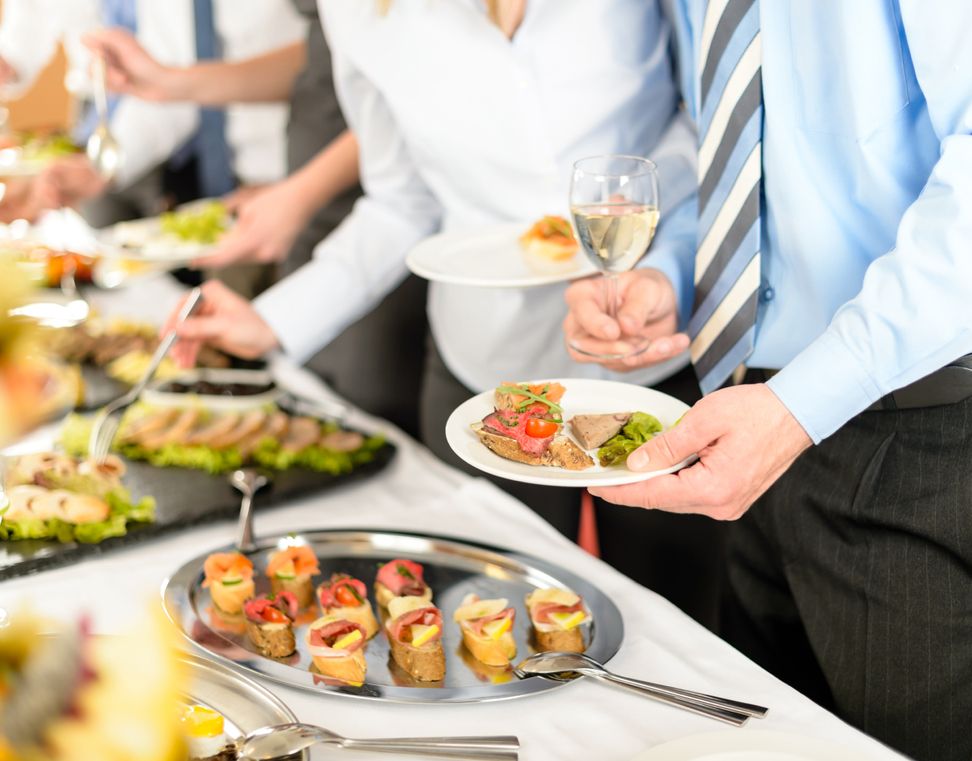 Gäste servieren sich Fingerfood und Canapés vom Catering des Party Service Becker bei einer Firmenveranstaltung.